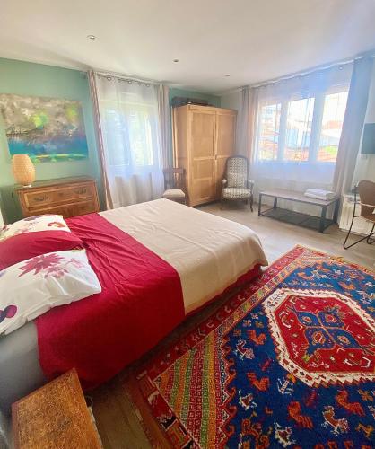 - une chambre avec un lit doté d'une couverture rouge et d'un tapis dans l'établissement Jolie maison Parisienne Jardin Porte de Montreuil, à Bagnolet