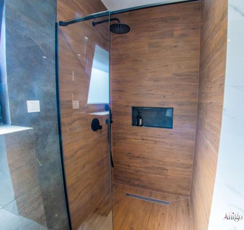 a shower with wooden walls and a glass door at Villa River in Mostar