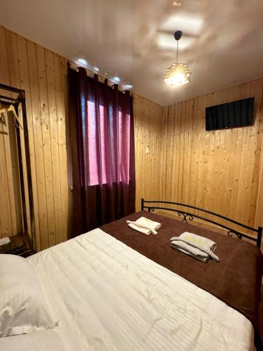 a bedroom with a bed with two towels on it at Davitiani in Tʼelavi