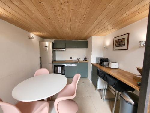 une cuisine avec une table blanche et des chaises roses dans l'établissement PartDieu, rénové, climatisation !, à Lyon