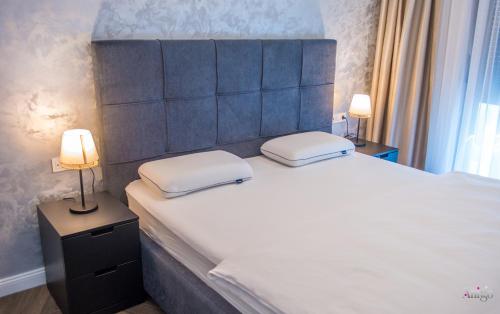 a bedroom with a large white bed with two lamps at Villa River in Mostar