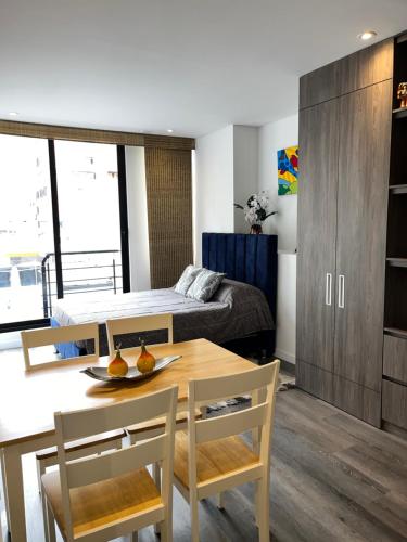 ein Schlafzimmer mit einem Bett und einem Tisch und Stühlen in der Unterkunft Loft Cool Universal in Bogotá
