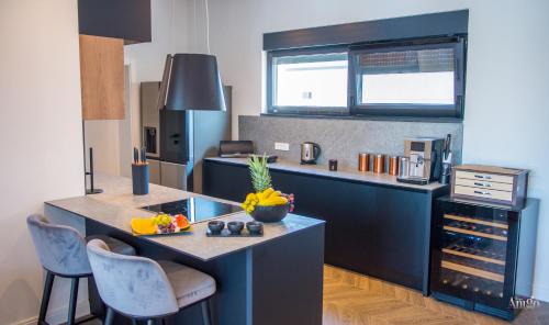 a kitchen with a island with a counter and chairs at Villa River in Mostar