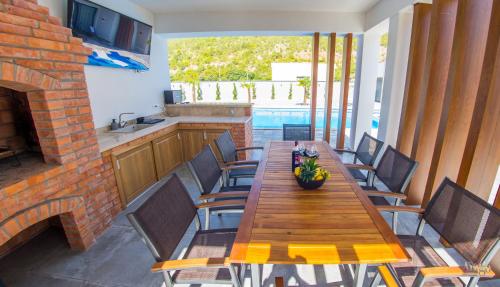 a wooden table and chairs in a kitchen with a fireplace at Villa River in Mostar