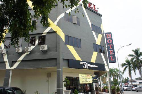 a building with a yellow stripe on the side of it at No.31 Maple Inn in Simpang Ampat