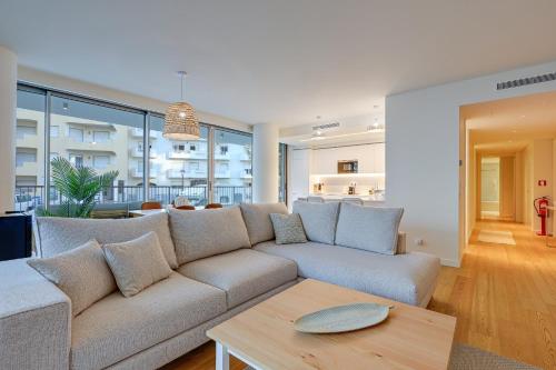 una sala de estar con un sofá y una mesa en Algarve Coast Casa - Pool, Gym & Spa, en Armação de Pêra