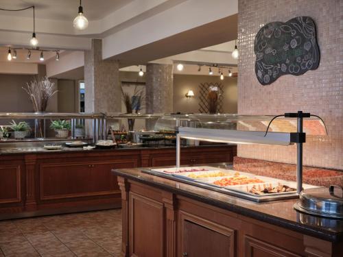 a buffet line with food on a counter in a restaurant at Atlantica Princess Hotel in Ixia