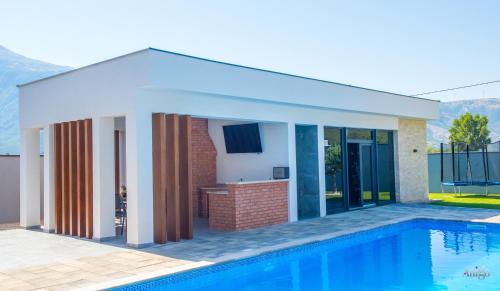 a house with a swimming pool next to a house at Villa River in Mostar
