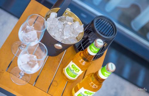 two bottles of beer and glasses on a table at Villa River in Mostar