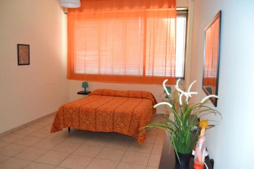 een slaapkamer met een bed en een raam en een plant bij Victoria House in Catania
