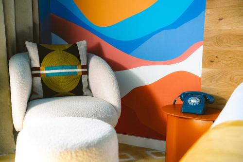 a chair with a pillow and a clock in a room at Big Sky Hotel & Spa in Chamonix-Mont-Blanc