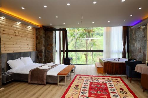 a hotel room with a bed and a bath tub at Yamacda Suit Otel in Çamlıhemşin