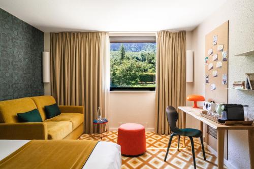 a hotel room with a bed and a couch and a window at Big Sky Hotel & Spa in Chamonix-Mont-Blanc