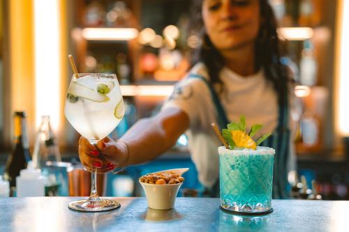 a woman sitting at a table holding a drink at Big Sky Hotel & Spa in Chamonix-Mont-Blanc