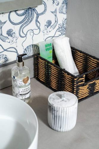 a bathroom counter with a bottle of soap and baskets at Entire Beach Home Away from Home in Rosarito