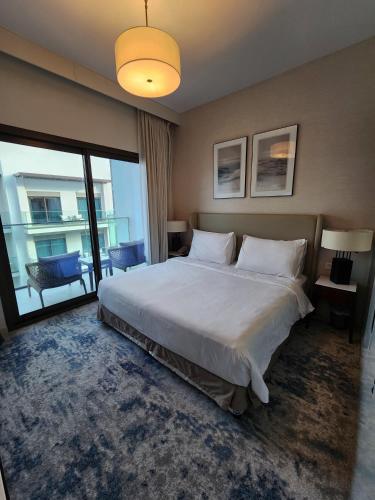 a bedroom with a large bed and a large window at Solo RealtyHH Apartments - Address Residence Fujairah in Sharm