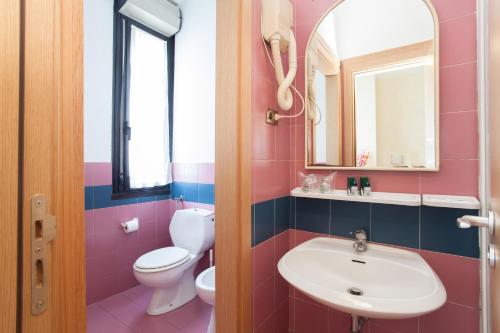 a pink bathroom with a sink and a toilet at Residence Lepontina in Milan