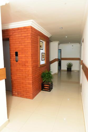 an empty hallway with a brick wall and two plants at Paray Village County in Kollengode