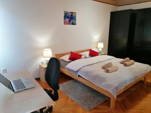 赛斯韦泰Cozy 1-bdrm apt in Dubec, ideal for work or study的一间卧室，配有一张床和一张带笔记本电脑的书桌