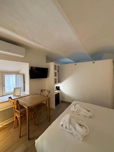 a room with a table and a bed and a desk at La Maison des Vendangeurs - TABLE D'HÔTES le soir du jeudi au dimanche- Jacuzzi - Balnéo SPA - ACCES PISCINE pour toutes les chambres sauf STUDIO COQUET- Piscine de mai à mi-octobre in Martignargues