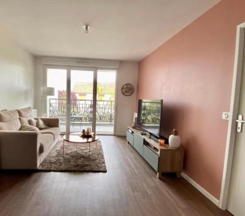 un salon avec un canapé et une télévision dans l'établissement Bel apparemment bien équipé, à Pontault-Combault