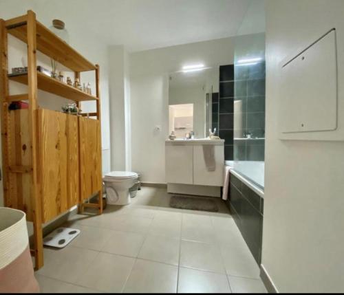 une salle de bain blanche avec des toilettes et un lavabo dans l'établissement Bel apparemment bien équipé, à Pontault-Combault