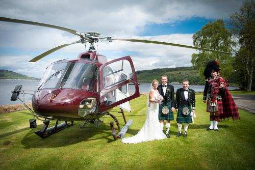 a bride and groom standing next to a helicopter at Bunchrew House Hotel in Inverness