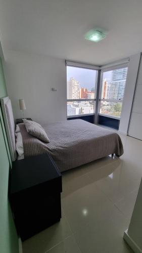 a bedroom with a bed and a large window at Nancy Forest 888 in Punta del Este
