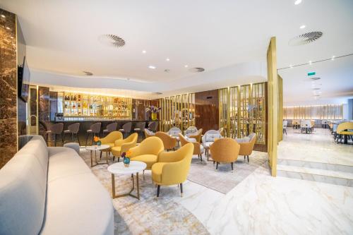 a restaurant with couches and tables and chairs at VIP Executive Suites do Marquês Hotel in Lisbon