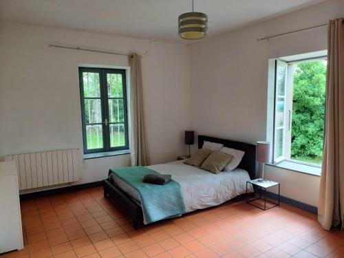 sypialnia z łóżkiem i 2 oknami w obiekcie Maison de Pierre 4 à 6 personnes w mieście Lempaut