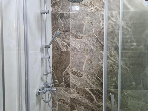 a shower with a glass door in a bathroom at Sumgait Seaside Apartment in Sumqayyt