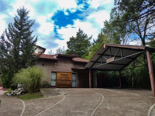 a house with a garage with a basketball hoop at Hotel Antiguo Camino in Villa General Belgrano