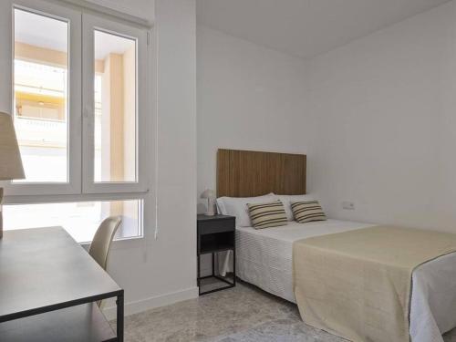 a bedroom with a bed and a desk and a window at Oasis Junto al Mar a 2 minutos de playa Sagunto A6 in Puerto de Sagunto