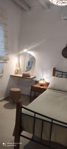 a bedroom with a bed and a mirror and a table at Avlidaki house in Exámbela