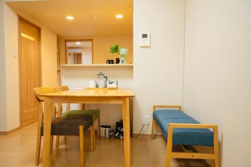 大阪市にある天六苑宿のテーブル、椅子、ベッドが備わる客室です。