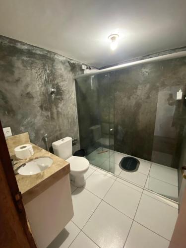 a bathroom with a toilet and a glass shower at Chalé Vista Encanto dos Montes in Monte das Gameleiras