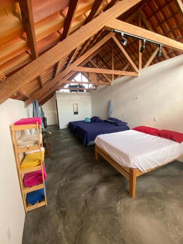 a attic bedroom with two beds and a ladder at Chalé Vista Encanto dos Montes in Monte das Gameleiras