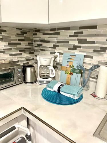a kitchen counter with a coffee pot and a towel at Bright & Cozy Family Home Near Dania Beach in Dania Beach