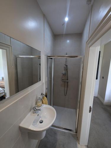 a white bathroom with a shower and a sink at Plantation Drive - Home from home in Limavady