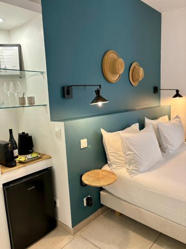 a bedroom with a bed with a blue wall at La Maison des Vendangeurs - TABLE D'HÔTES le soir du jeudi au dimanche- Jacuzzi - Balnéo SPA - ACCES PISCINE pour toutes les chambres sauf STUDIO COQUET- Piscine de mai à mi-octobre in Martignargues
