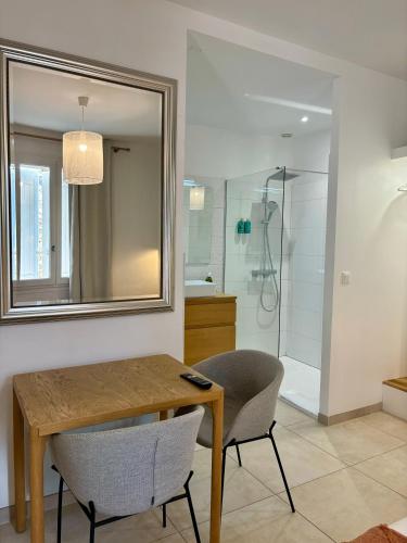 a bathroom with a table and a mirror and a shower at La Maison des Vendangeurs - TABLE D'HÔTES le soir du jeudi au dimanche- Jacuzzi - Balnéo SPA - ACCES PISCINE pour toutes les chambres sauf STUDIO COQUET- Piscine de mai à mi-octobre in Martignargues