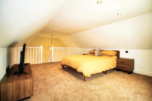 a bedroom with a bed and a flat screen tv at Sleeps 4 - Town Centre - Very High End Renovation - Private Garden - Close to Train Station - Fast Wifi in Berwick-Upon-Tweed