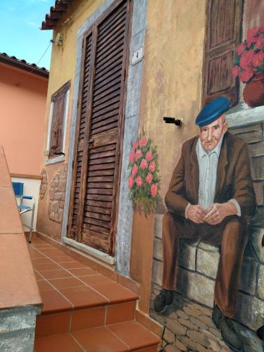 a painting of a man sitting on a wall at Sotza’s Little House in Padru