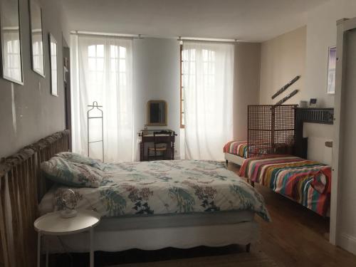 a bedroom with a bed and a table and window at Etape en Barétous - 6 personnes in Aramits
