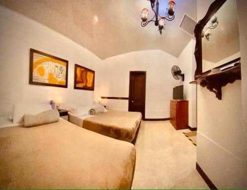 a hotel room with two beds and a chandelier at Hospedaje Camino Real a 150 MTS del centro in Salento