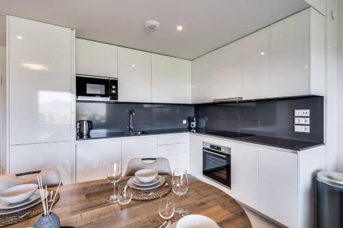 a kitchen with white cabinets and a wooden table at Ultimate Rentals - Ipanema Del Sol - Relax With Scenic Views in Mijas