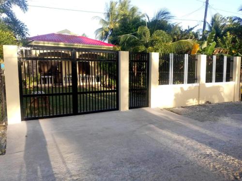 a black gate with a white fence at Regina Vacation House in Tayud