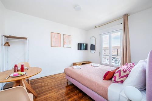 une chambre avec un lit, une table et une fenêtre dans l'établissement Charmant studio en banlieue parisienne - Montreuil, à Montreuil