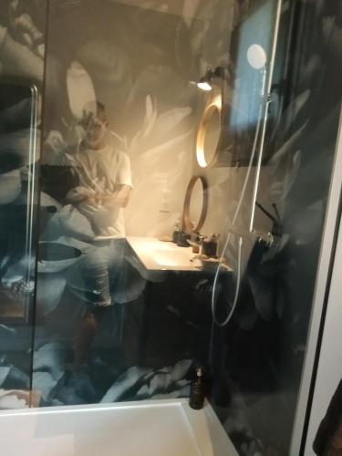 un homme assis dans une salle de bains avec un miroir dans l'établissement LS normandie, à Saint-Pois