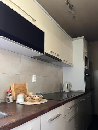 a kitchen with white cabinets and a counter top at Delux apartman in Leskovac
